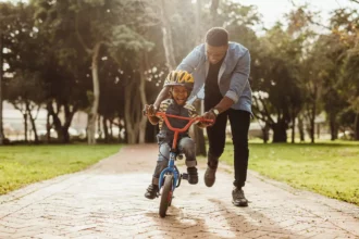 African father teaching his son to ride a bike