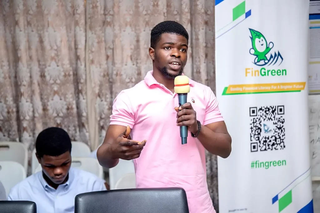 Student asking questions at QNET's FinGreen financial literacy programme in Accra