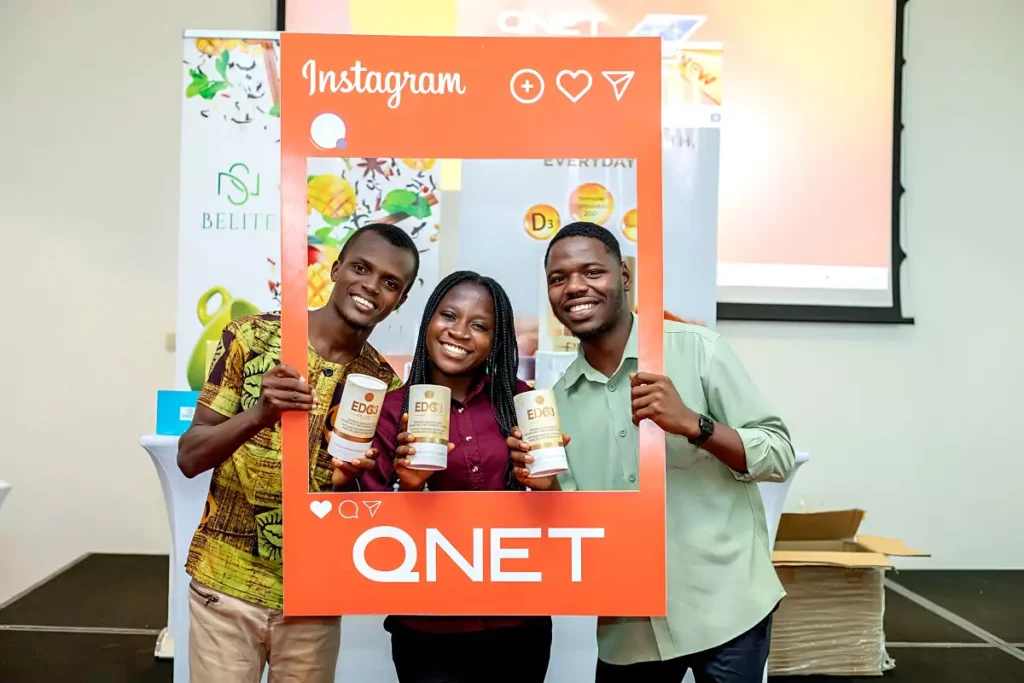 Photo with 3 Ghanaians smiling holding a frame with QNET and Edg3 Plus